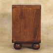 Chestnut 2 drawer nightstand next to a bed with a lamp and books on top
