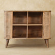 Larissa open cabinet with rattan design and small shelves in a room setting