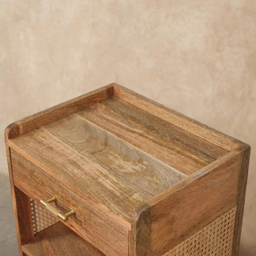Angled view of the bedside table showing the drawer and open storage in a bedroom