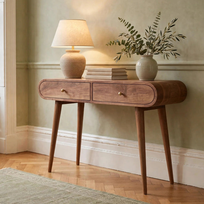 Light walnut console table with curved edges and two drawers, shown in a room