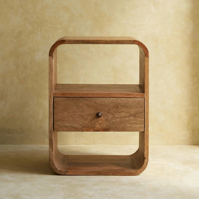 London Bedside table with an oak-ish finish and two open storage slots beside a bed
