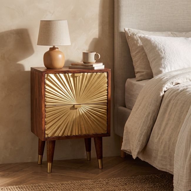 Manila Gold chestnut mango wood bedside table with brass-plated drawers in a bedroom