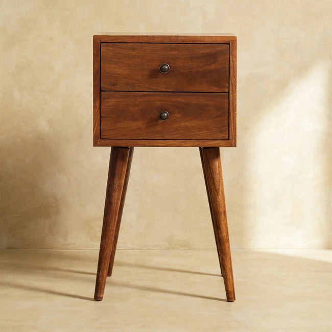 Chestnut mango wood bedside table with two small drawers next to a bed