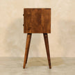 Chestnut mango wood bedside table with two small drawers next to a bed