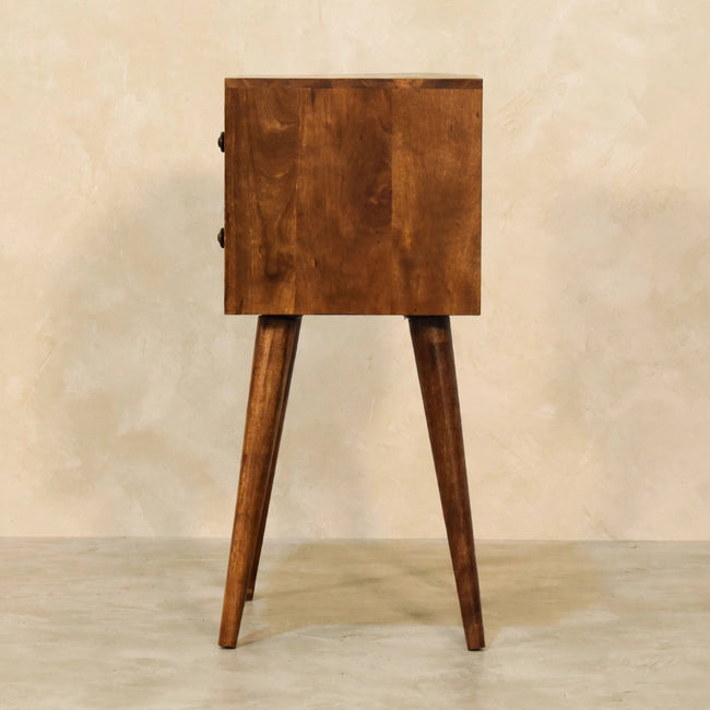 Chestnut mango wood bedside table with two small drawers next to a bed