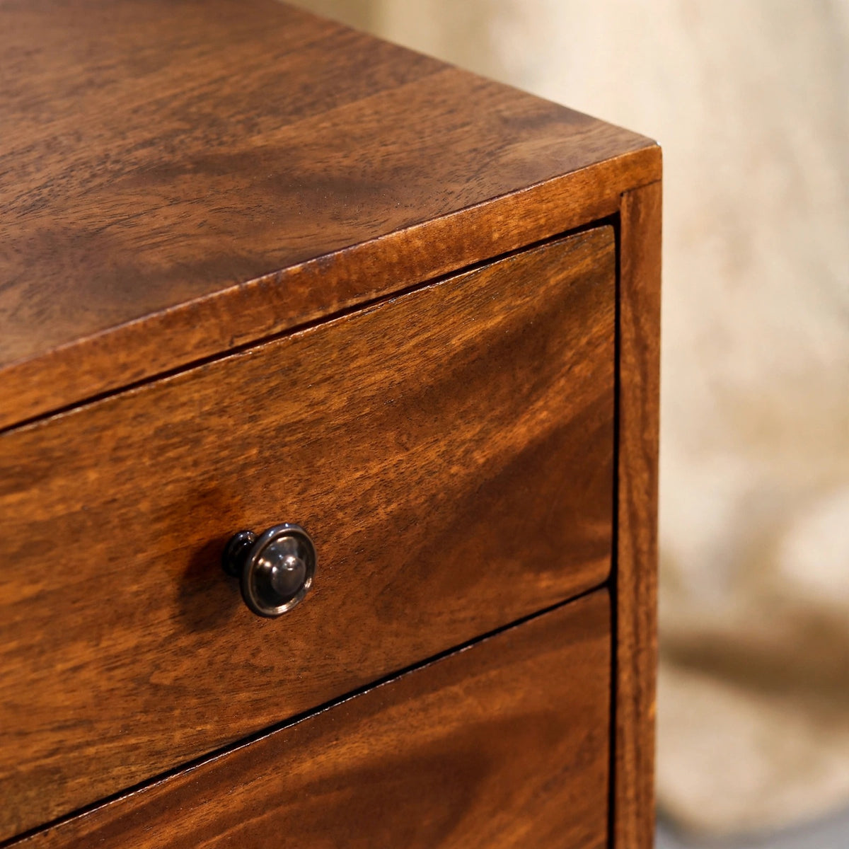 Compact two drawer bedside table with Scandinavian-style legs in a room setting