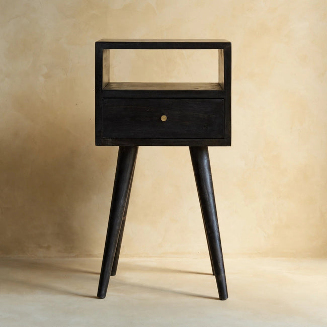 Black bedside table with one drawer and one open shelf shown in a room setting
