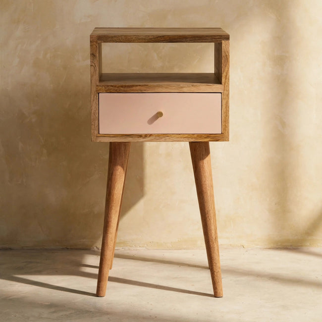 Solid mango wood bedside table with oak-ish finish beside a bed