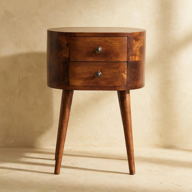 Chestnut bedside table with two mini drawers and shiny knobs next to a bed