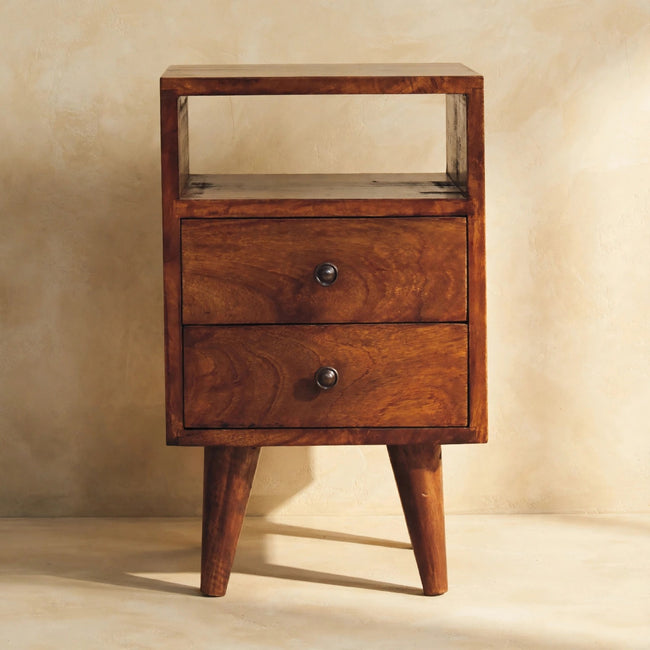 Chestnut mango wood bedside table with brass knobs next to a bed