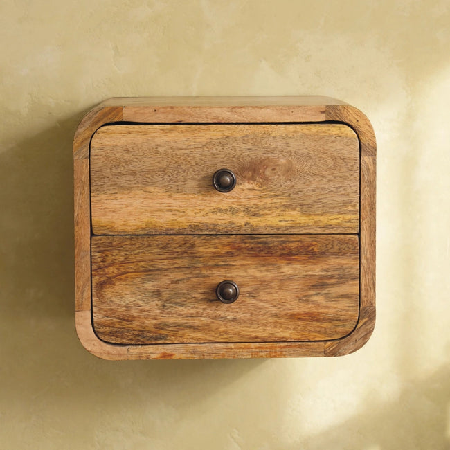 Wall-mounted mango wood bedside unit with two drawers and shiny knobs in a bedroom setting