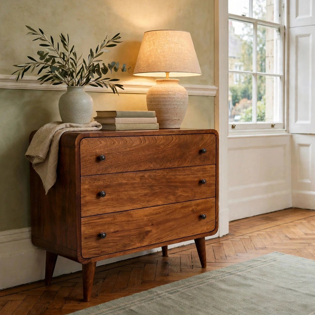 Mini curved chest of drawers in chestnut solid mango wood styled in a bedroom