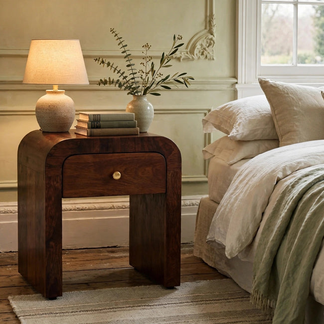 Mini Darcy chestnut mango wood nightstand with curved edges styled in a bedroom