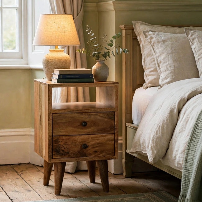 Solid mango wood bedside table with two drawers and brass knobs in a bedroom