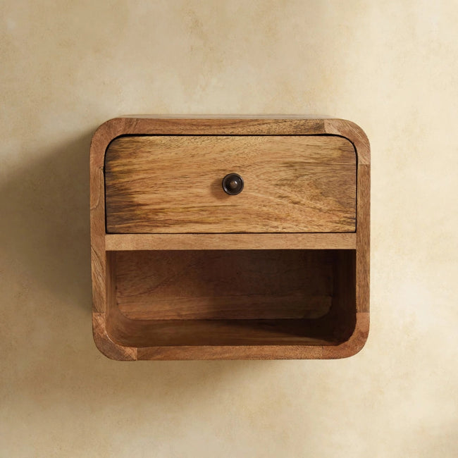 Wall-mounted mango wood bedside table with one drawer and one open slot in a bedroom