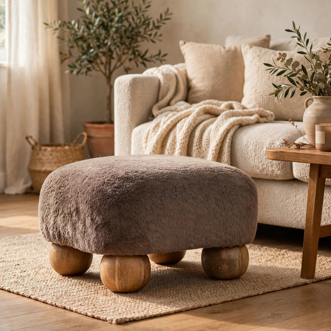 Mocha faux fur footstool with a square seat shown in a living room