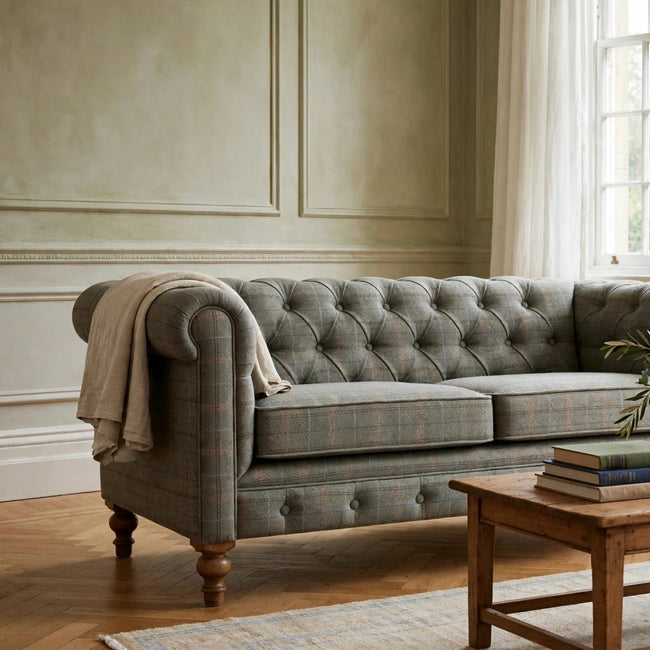 Multi tweed 2 seater Chesterfield sofa with a button tufted back and sheltering arms in a living room