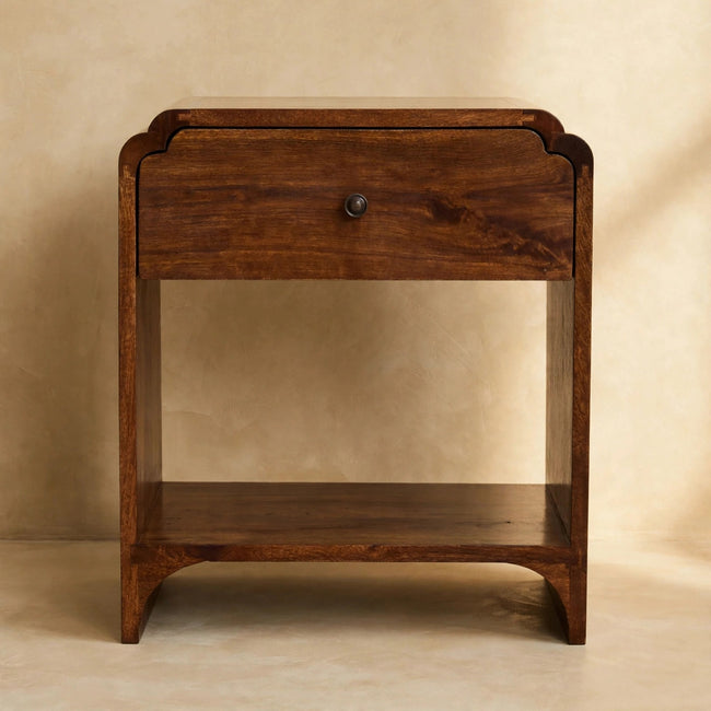 Newton bedside table beside a bed, showing the drawer and open shelf below