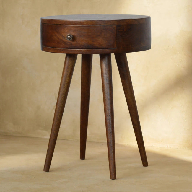 Nordic Chestnut round bedside table beside a bed in a styled room
