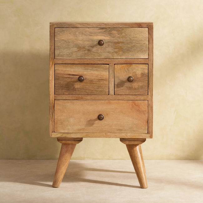 Mango wood bedside table with four drawers and metal knobs beside a bed