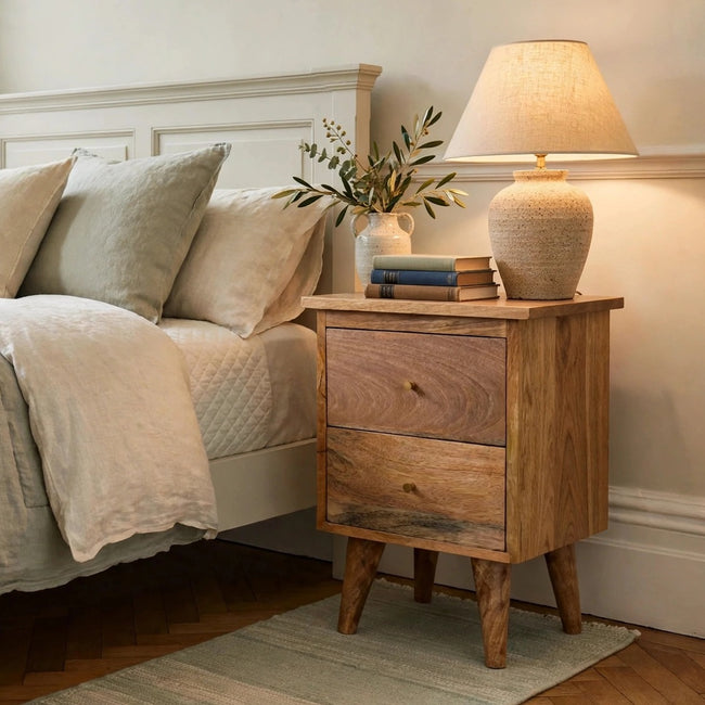 Oak-ish solid mango wood bedside table with two drawers, shown in a bedroom