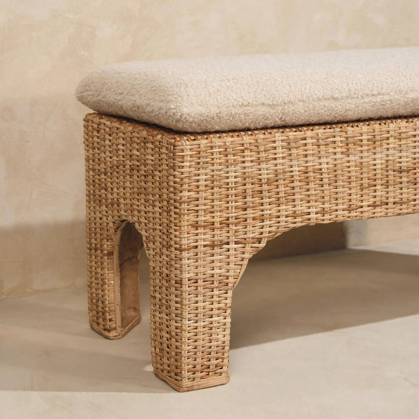 Handwoven rattan and mango wood bench seen from an angle in a room