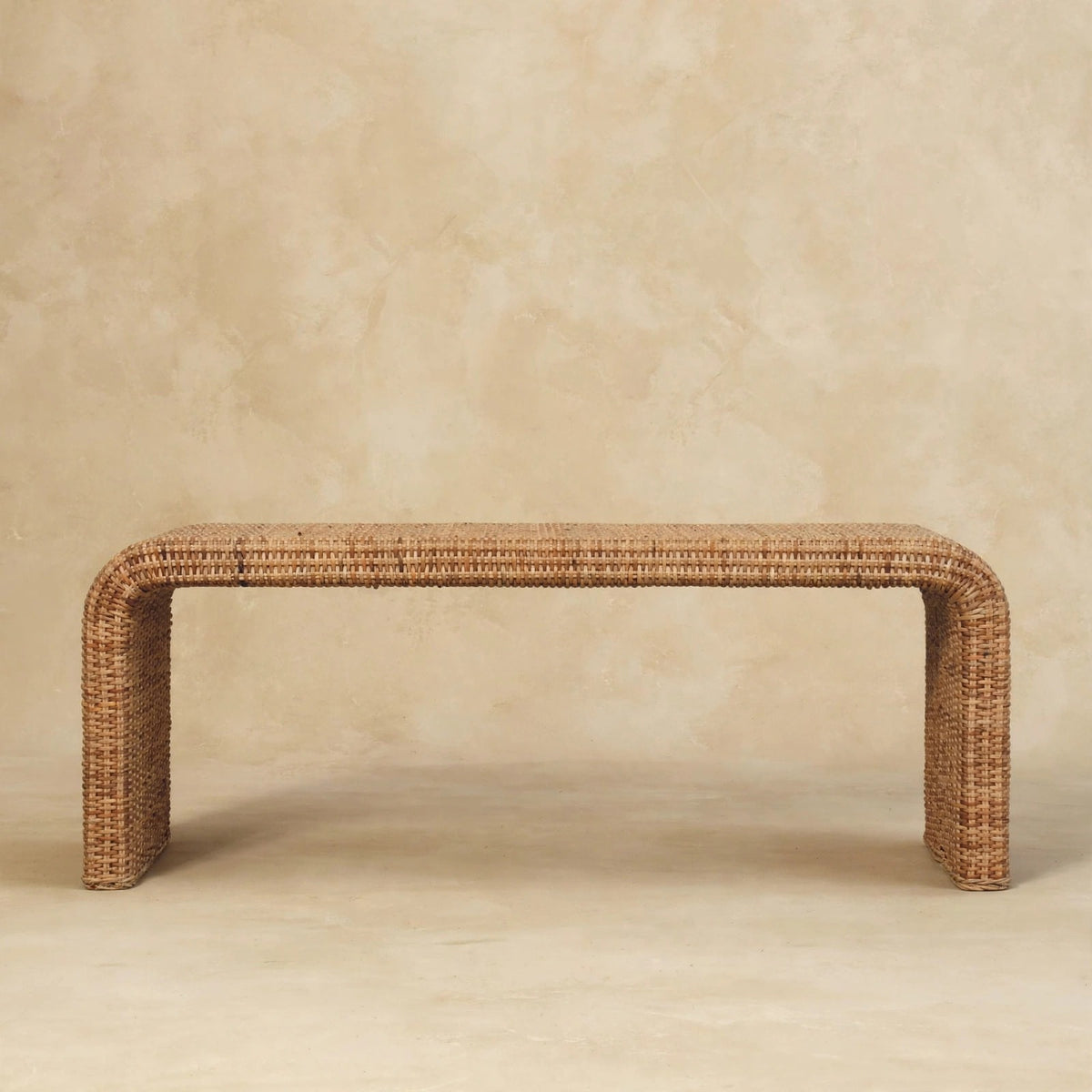 Rattan weave bench with warm oak-style finish seen from the front in a room