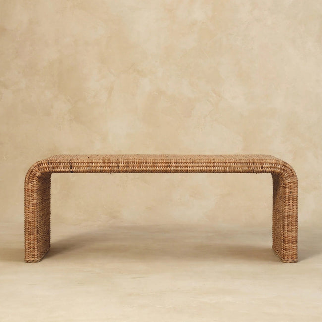 Rattan weave bench with warm oak-style finish seen from the front in a room
