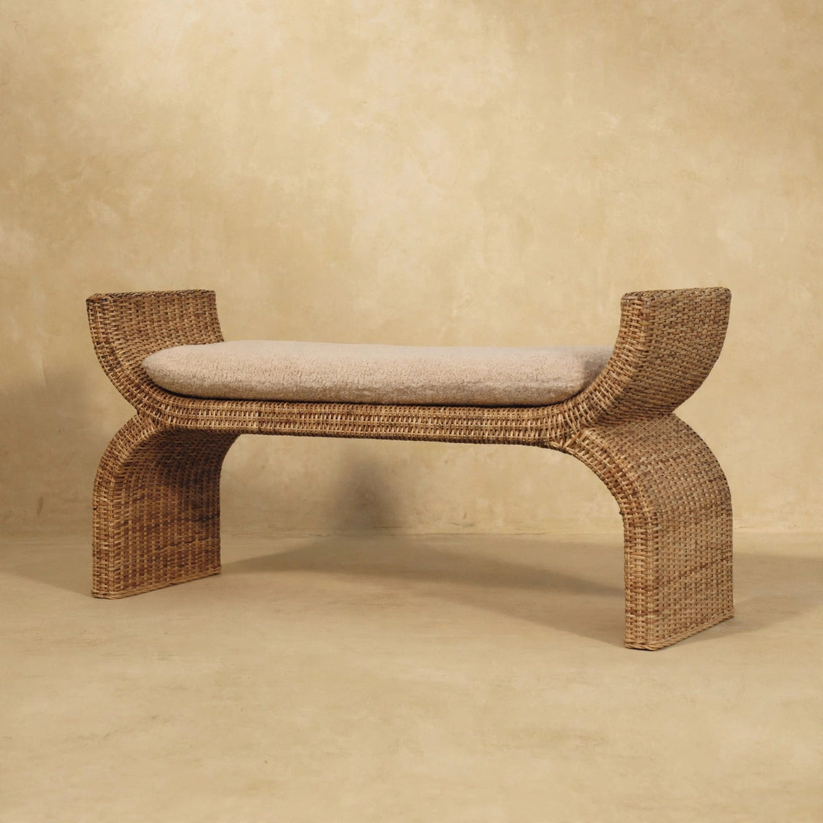 Rattan weave boucle bench placed in a hallway with decor around it
