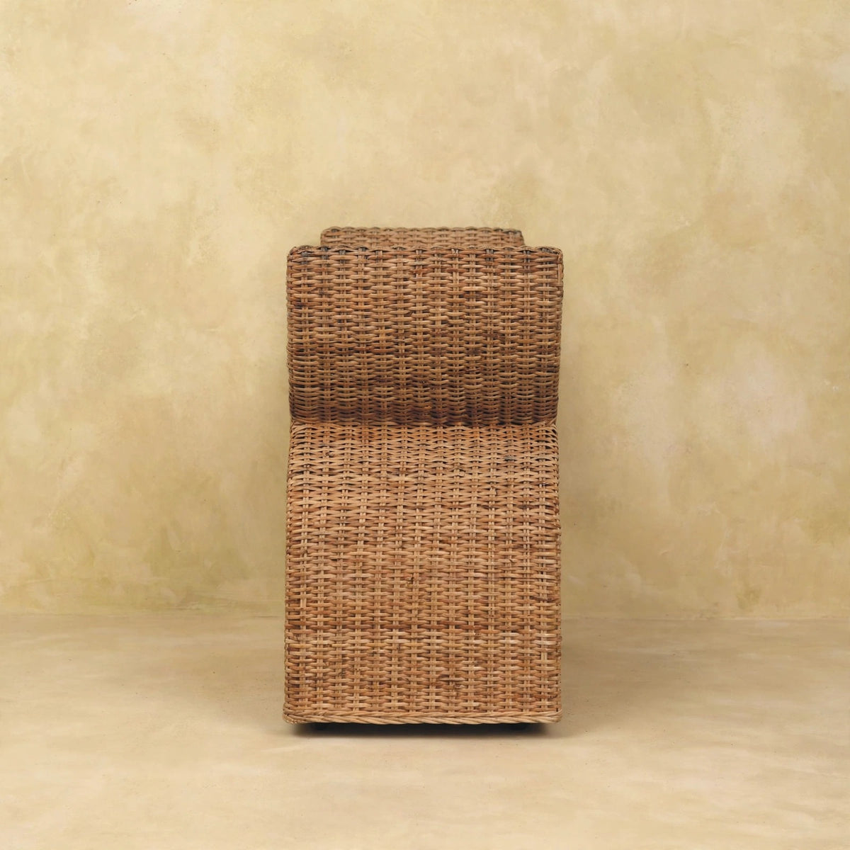 Front view of the boucle bench with woven rattan detail in a room