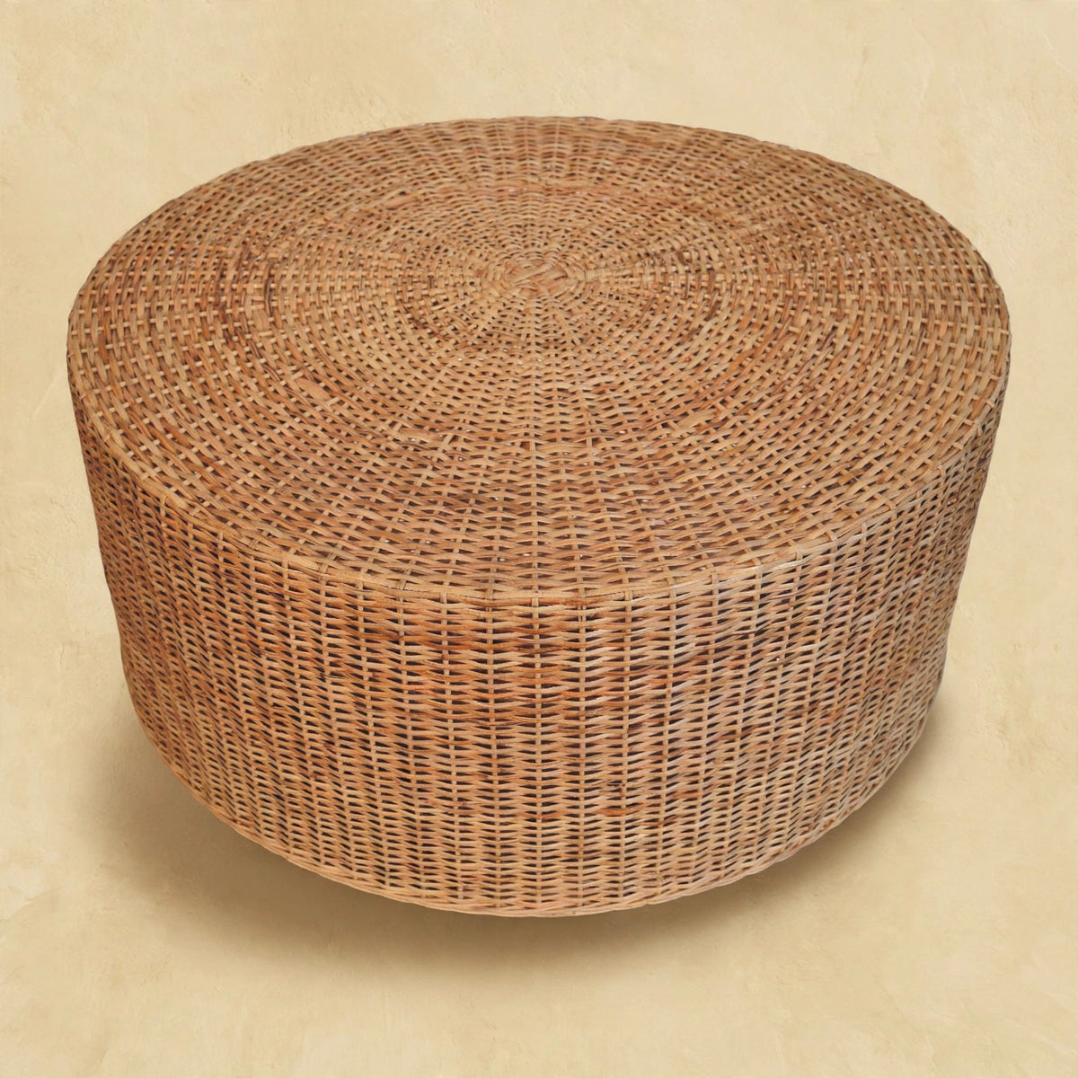 Side view of a round woven coffee table showing the woven base in a room