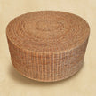 Side view of a round woven coffee table showing the woven base in a room