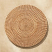 Round woven coffee table as a centerpiece in a styled living space