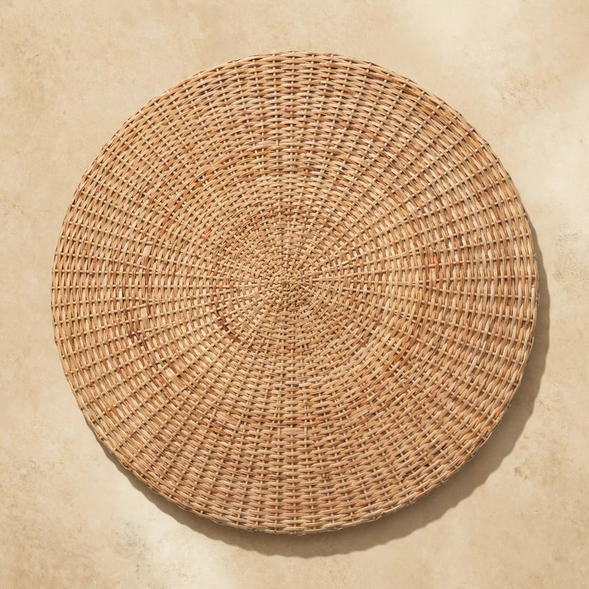Round woven coffee table as a centerpiece in a styled living space