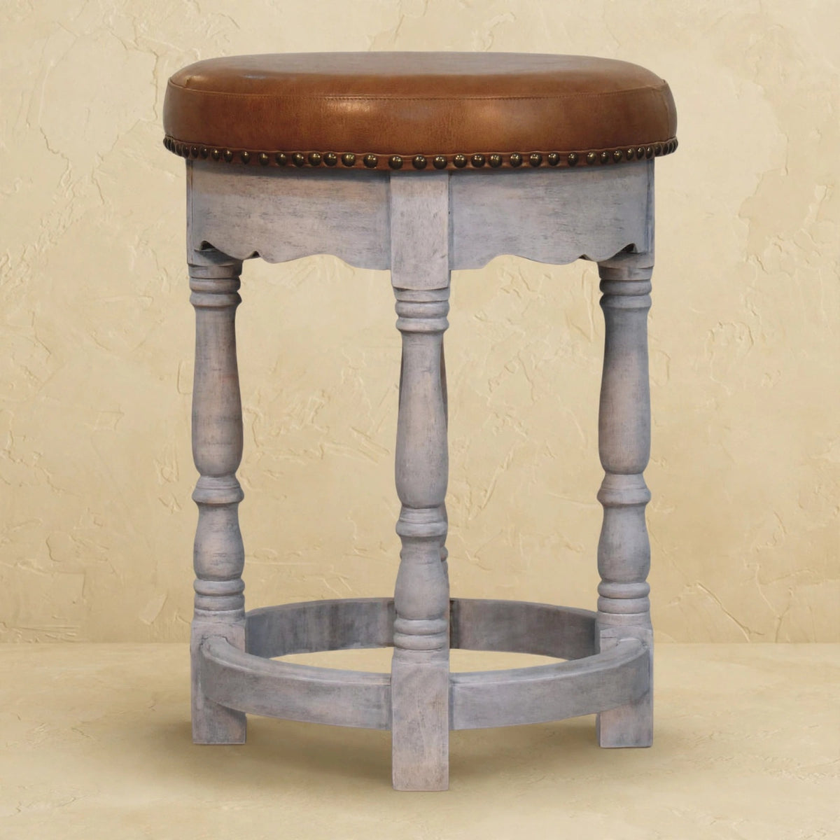 Close-up of the acid wash mango wood finish and leather seat of the Rustic Charm stool