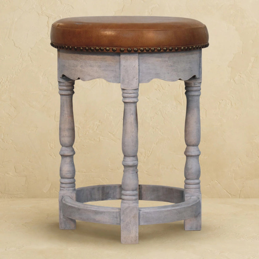 Close-up of the acid wash mango wood finish and leather seat of the Rustic Charm stool