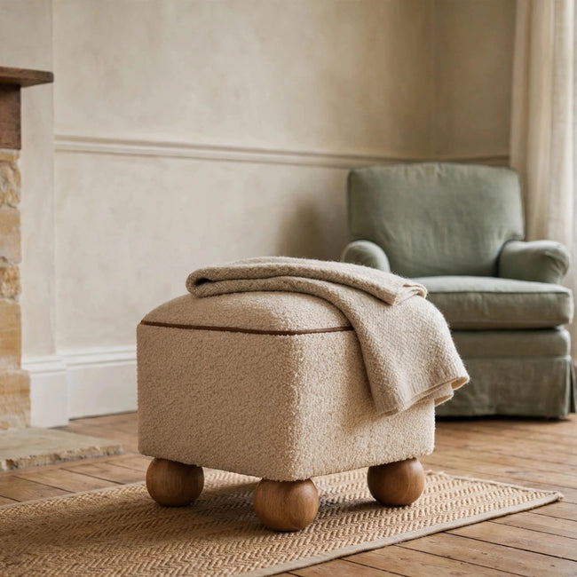 Serenity round woven footstool with leather piping and wooden ball feet in a living room