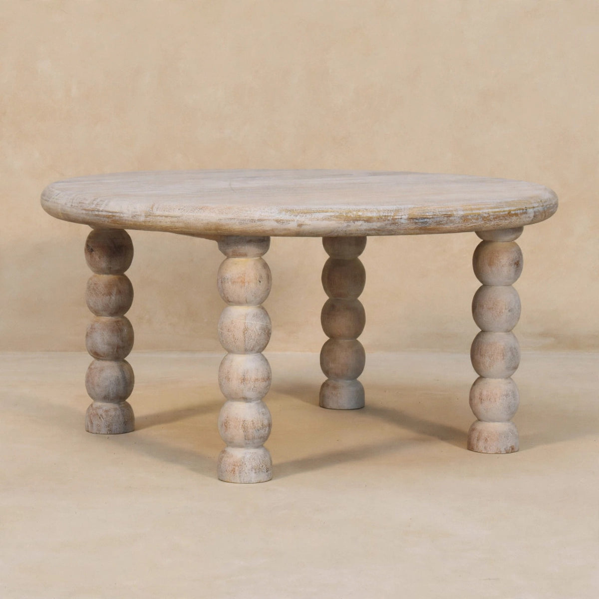 Round Salted Oak coffee table with spindle legs in a living room setting