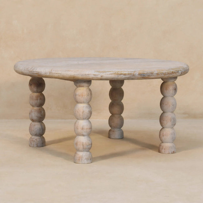 Round Salted Oak coffee table with spindle legs in a living room setting