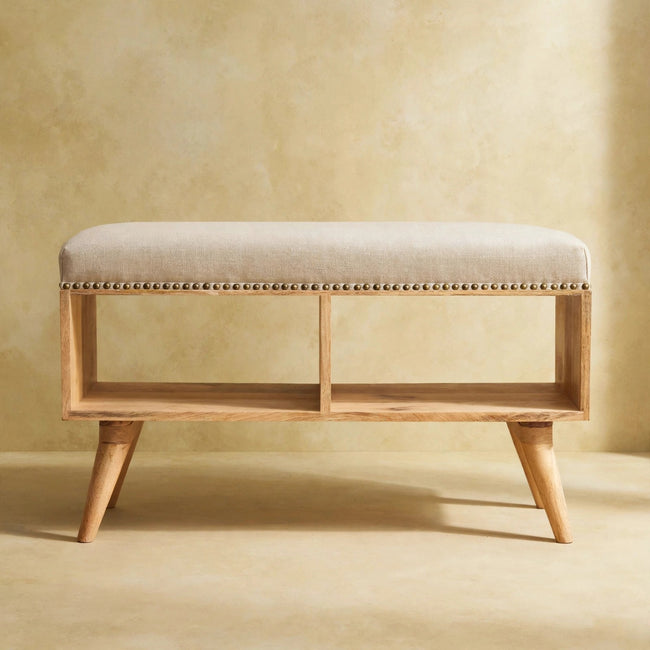Front view of the cream linen bench with studded rim in a room setting
