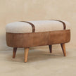Boucle seat and buffalo leather base of the tan bench in a room