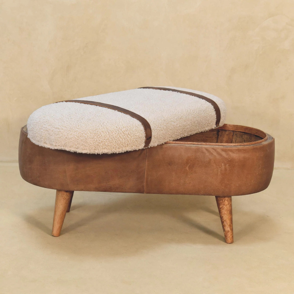 Tan boucle bench with leather straps in a hallway-style setting