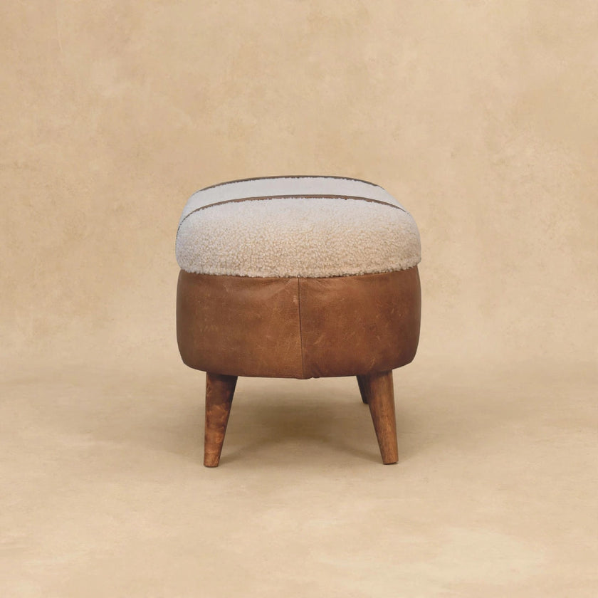 Angled view of the tan boucle and buffalo leather bench in a room