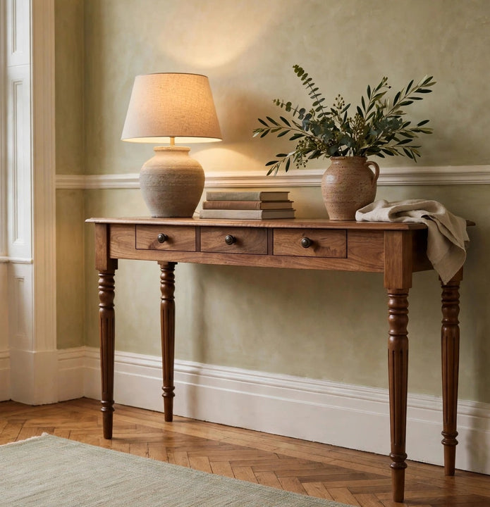 Three drawer console table in Honey Caramel mango wood with turned legs, shown in a room setting