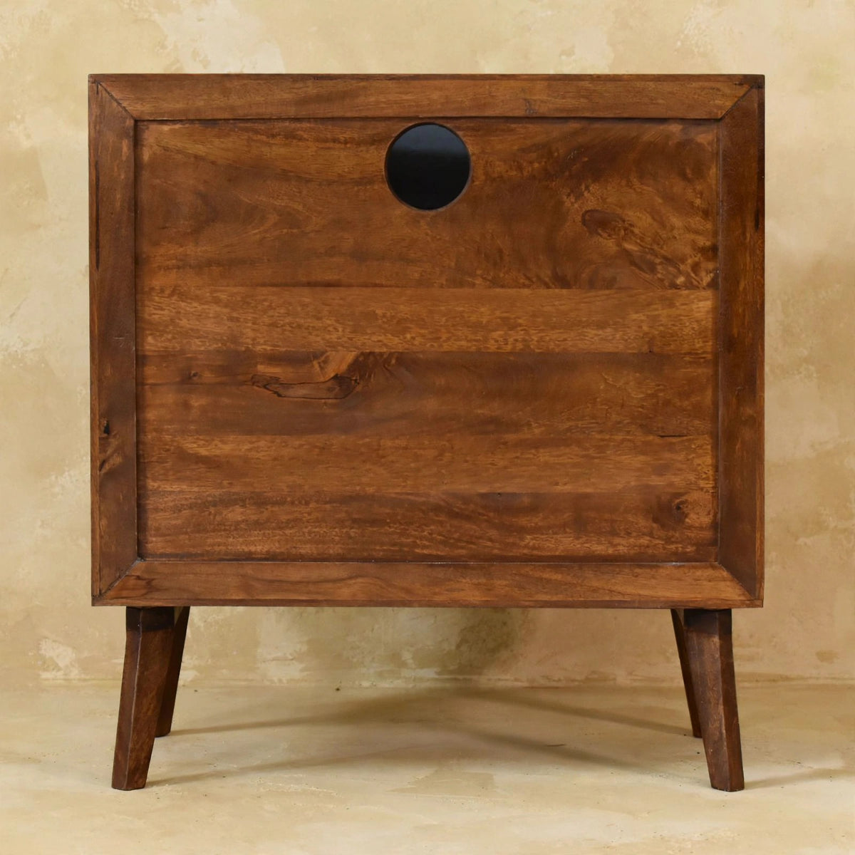 Tova open shelf cabinet in a living room, showing the solid mango wood grain and finish