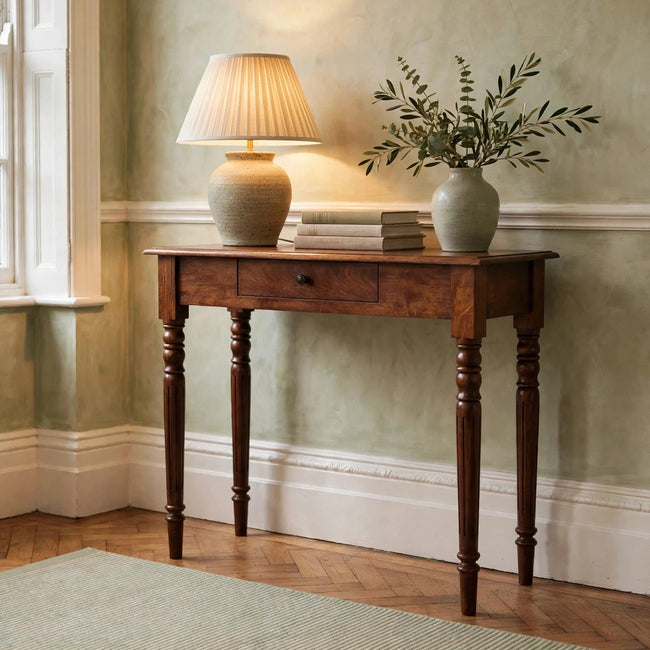 Chestnut mango wood console table with one drawer and turned legs in a styled room