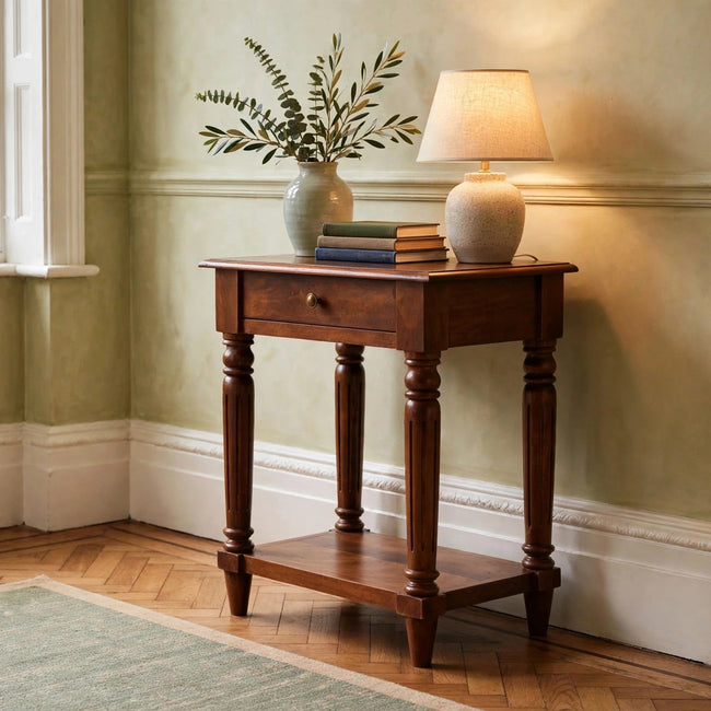 Chestnut mango wood side table with turned legs and one drawer in a room setting