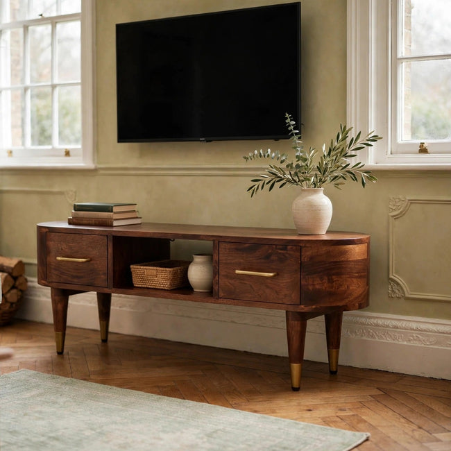 Valenza curved media console in solid mango wood with brass handles, styled in a living room