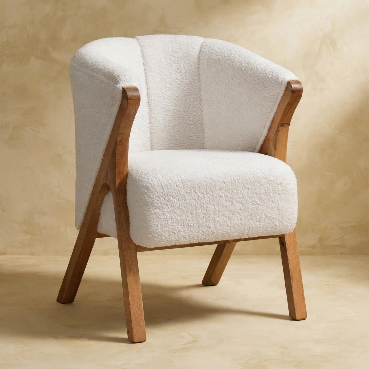 Side angle of the white boucle chair showing its rounded shape and wooden legs