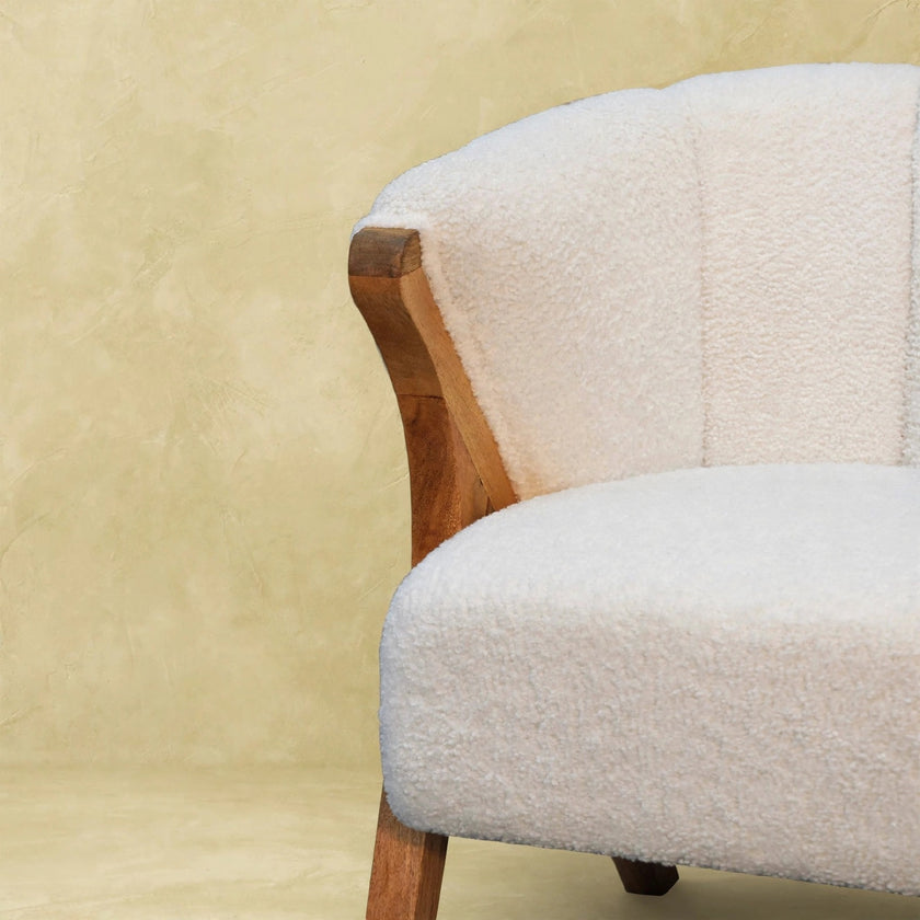 White boucle minimalistic chair styled in a bedroom or study corner